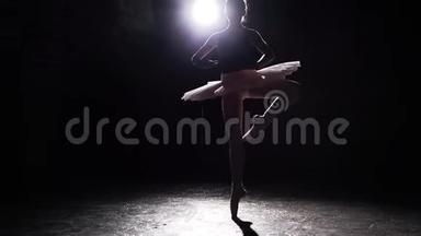 美丽的年轻优雅的芭蕾舞演员在黑混凝土地板背景的尖角鞋。 芭蕾舞练习。 慢动作。