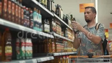 年轻人在<strong>杂货店里</strong>挑选橄榄油，从货架上拿瓶子