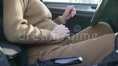 孕妇在车上，照顾孕妇抚摸腹部，并在驾驶车辆前系上安全带