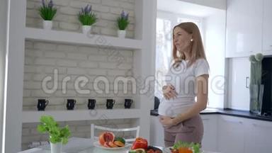 <strong>孕期</strong>的维生素食品，可爱的未来妈妈，在早午餐时在厨房里用新鲜蔬菜跳舞