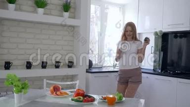 有趣的健康孕妇，早餐时在厨房<strong>大肚皮</strong>跳舞，吃蔬菜和水果