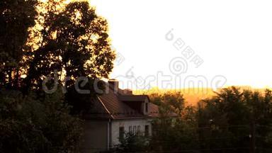<strong>金色</strong>的夕阳光透过树木的叶子，反光，旧房子，城市屋顶的全景