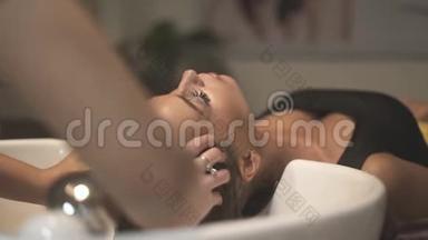 发型师在美容工作室洗头时做头部按摩。 理发师在理发时做头部按摩
