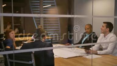 商业团队坐在一张桌子旁，男人戴着虚拟现实护目镜。 人们在<strong>办公会议</strong>上测试vr耳机。
