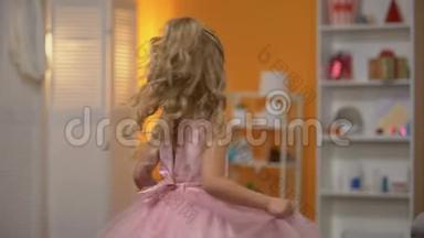 可爱的小女孩穿着粉红色的裙子跳舞，假装是公主，幸福