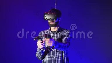 人玩3D虚拟现实游戏.. 在射击<strong>VR</strong>游戏中使用控制器射击。 穿着蓝色<strong>VR</strong>耳机的男人