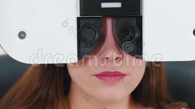 <strong>眼科</strong>治疗-一名年轻妇女用特殊的验光设备检查视力-一台机器