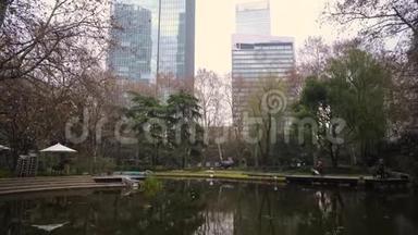 中国上海市中心摩天大楼背景下的池塘公园