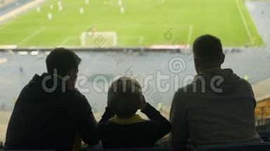 男球迷带着孩子在体育场看足球，保持沉默，失望