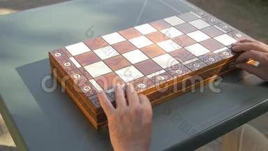 老人打开花园里的棋局盒子，把白色的数字并排放在桌子上。