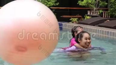 亚洲小女孩学习游泳从母亲在游泳池照顾暑假日。