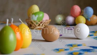 复活节快乐。雌手从桌上取下两个复活节彩<strong>蛋</strong>。五颜六色的蜡烛和彩<strong>蛋</strong>
