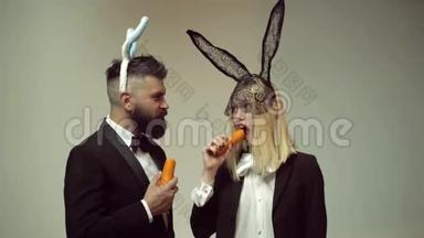 快乐有趣的复活节夫妇与胡萝卜。 家人庆祝复活节。 复活节兔子。 一对有兔子耳朵的。 有趣的复活节