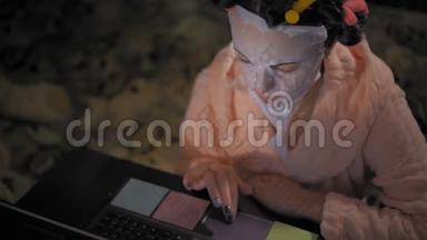 特写镜头，粉色罗贝中的女人在笔记本电脑上重<strong>新焕</strong>发青春的面具