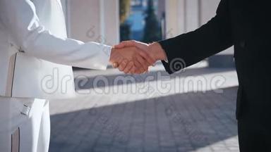 商人与女商人的同事握手，商人握手特写。 人们握手。