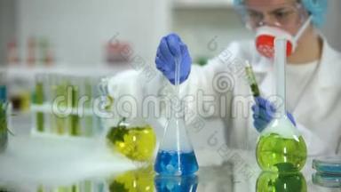 实验室<strong>研究人员</strong>在带绿色植物的试管中加入蓝色液体物质