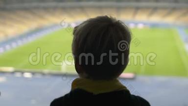 年轻男孩看着足球场，<strong>梦想</strong>成<strong>为</strong>足球运动员