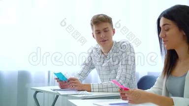 男、女学生在高中课堂上拿彩色卡片讨论作业