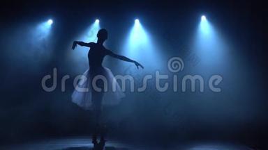 熟练的芭蕾舞演员穿着白色的芭蕾舞裙跳舞古典芭蕾。 慢动作。