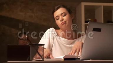 白种人女人无聊地坐在办公桌前，在室内使用笔记本电脑