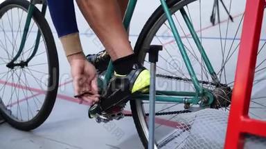 Cyclist将脚踏车和脚趾夹绑在velodrome轨道自行车门上的老式轨道自行车上