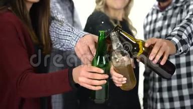 一群朋友用啤<strong>酒瓶碰杯</strong>。