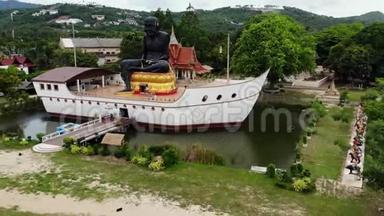 池塘里船上的黑色和尚雕像。 巨大的黑色和尚雕塑，位于船形结构中间的小池塘上
