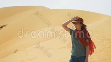 肖像：沙漠中的女孩旅行者在<strong>沙滩</strong>上。 戴着<strong>帽子</strong>和红领巾.. 探索古老的地形，寻找