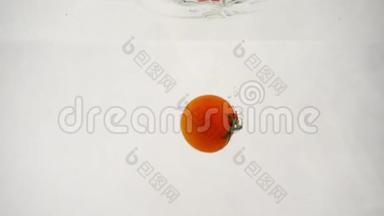 一个成熟的红樱桃番茄在白色背景下潜到水下