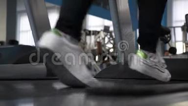 健身房减肥。 <strong>加强</strong>腿部肌肉跑。 穿运动鞋的女孩的腿在跑步机上特写。 在健身房散步