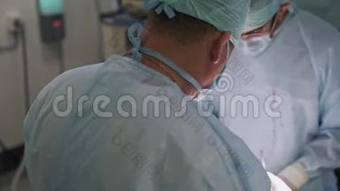 两名医生在手术期间穿着无菌衣服和口罩。 手术室的外科医生。 背面视图