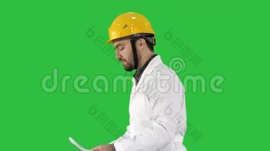 承包商工程师带着文件走，在绿色屏幕上检查周围，铬键。