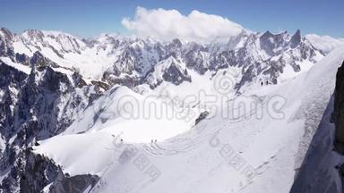 一群登山者爬上高山的积雪覆盖的山峰。