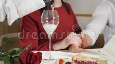 婚姻观念。 爱情和浪漫的关系。 服务员把香槟倒入玻璃杯中，让两个人慢动作。 特写镜头