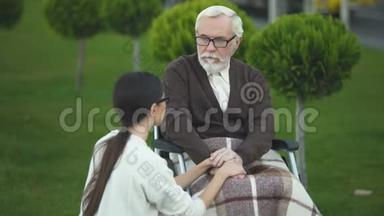 坐在轮椅上的老人和年轻的退伍老太太在和孙女聊天