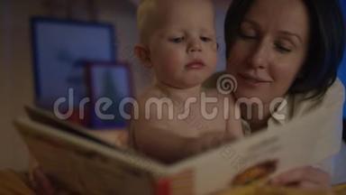 母亲给婴儿看书，躺在床上，用不同的照片，用流动相机给他治疗