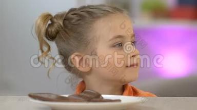 从桌子底下出现的女孩偷了一块巧克力棒，甜牙