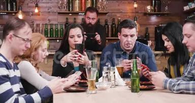 现代<strong>社会问题</strong>：酒吧里的朋友都看着他们的智能手机