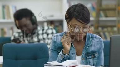 吸引<strong>人</strong>的非洲女学生在现代<strong>图书馆看书</strong>，而非洲男学生在使用智能手机