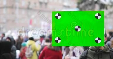 年轻人手里拿着绿色屏幕海报在城市示范。