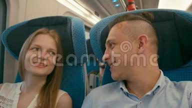 年轻夫妇乘火车度假时谈笑风生