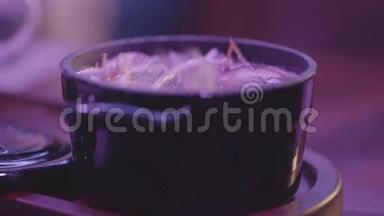 在一个黑碗里<strong>煮汤</strong>，桌上有个盖子。 健康食品概念。