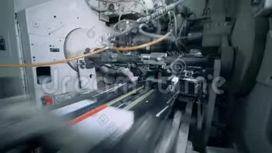 工厂机器在传送带上推动印刷书籍。
