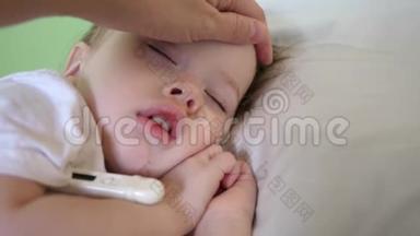 孩子生病了，在白床上用体温计睡觉。 妈妈用温度计测量婴儿的体温