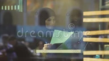 在咖啡馆里自信的阿拉伯商务小姐<strong>翻阅</strong>文件，自由