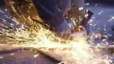 工人用磨床切割金属的特写。 磨铁时的火花