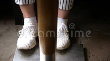 一个穿着白色运动鞋和黑白条纹裤子的女人的腿在桌子下面跺脚。