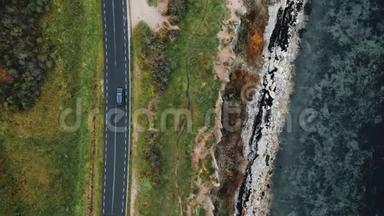 <strong>俯视</strong>图，无人机在跟踪黑色越野<strong>车</strong>行驶在美丽的侵蚀海岸线附近的秋季公路旅行。