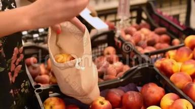 超市里的女人把新鲜水果送到棉花袋里。 没有塑料替代品。 零废物