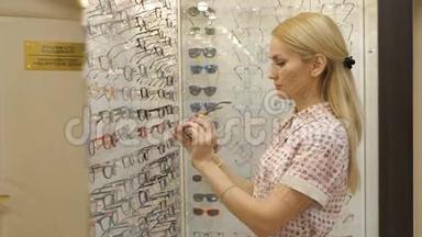 在光学商店里<strong>戴眼镜</strong>的年轻女人。 <strong>戴眼镜</strong>的<strong>漂亮</strong>女孩